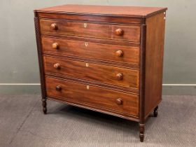 A 19th century flame mahogany chest of four long graduating drawers with bone escutcheons and spiral