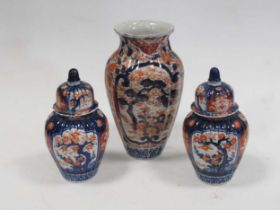 A pair of Japanese Imari clobbered melon fluted vases decorated with blossom trees 21cm high