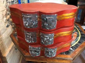 A set of three red lacquer boxes lozenge shaped boxes