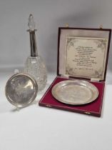 Two silver commemorative dishes and a silver mounted cut glass decanter, 10.9ozt weighable silver (