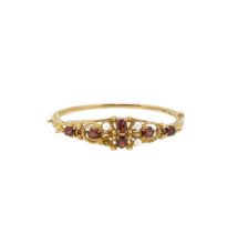 A late 20th century 9ct gold garnet and pearl hinged bangle,