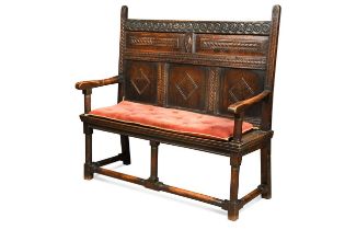 A carved oak panel back settle, 17th century and later,