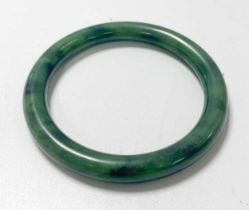 A Chinese mottled green jade bangle,