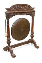 A late Victorian carved oak frame dinner gong with clapper,