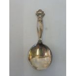 Georg Jensen: a caddy spoon with a foliate and scrolled finial.