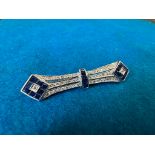A sapphire and diamond bar brooch set in white metal, stamped K18 and .50 (denoting diamond weight),