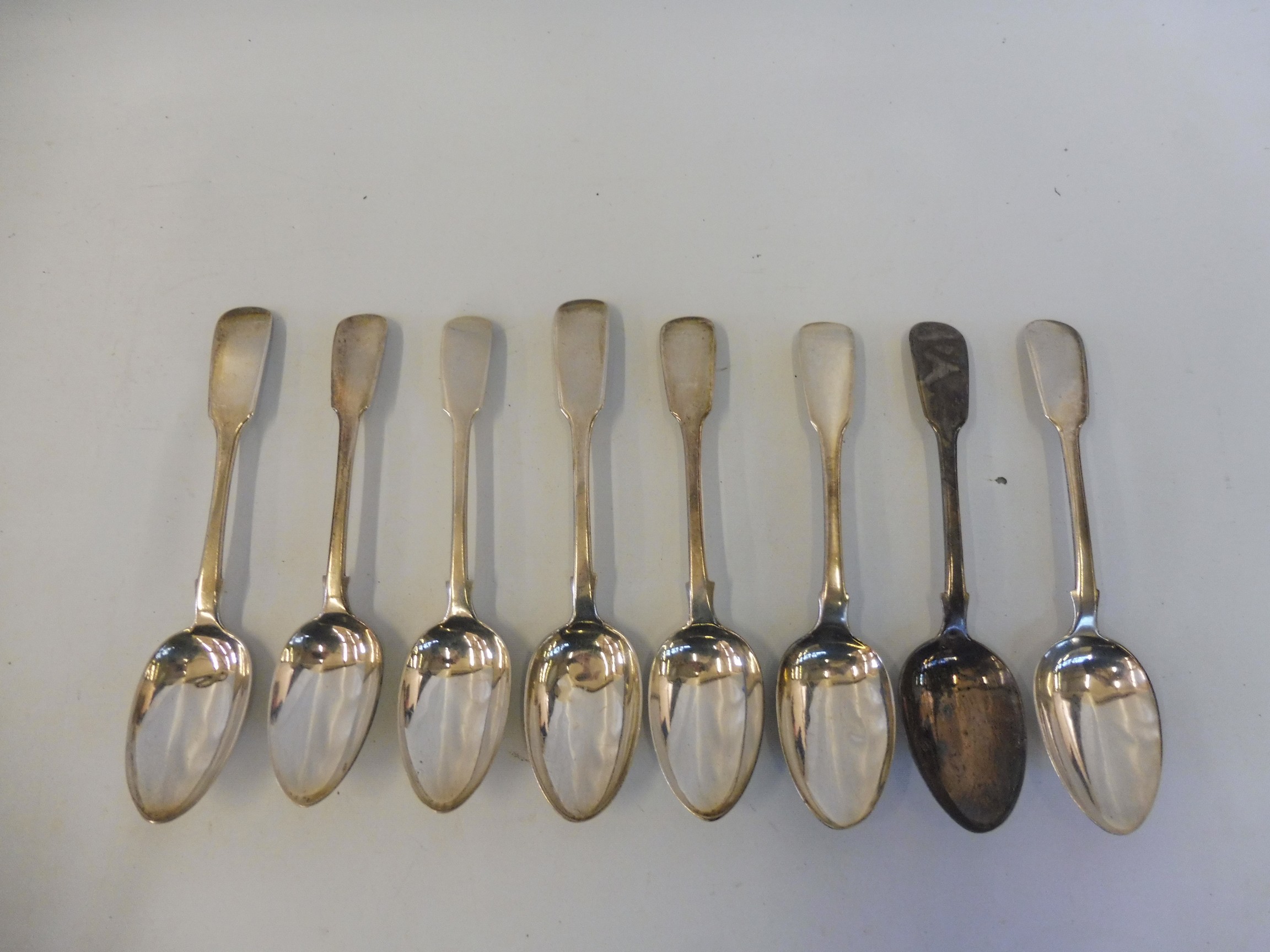 A collection of eight fiddle pattern dessert spoons, late Georgian and Victorian, various dates