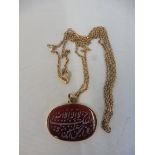 An unusual yellow metal and hardstone set pendant inscribed in Arabic.