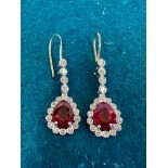 A pair of ruby and diamond drop earrings, two pear cut rubies and 36 round brilliant cut diamonds