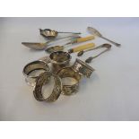 A collection of five napkin rings; a tea strainer and five other items.