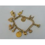 An 18ct gold bracelet with ten charms including a half sovereign, seven hallmarked 9ct gold and