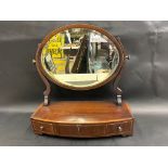 A 19th Century mahogany and banded oval toilet mirror, the bow front base fitted with three drawers,