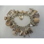 A silver charm bracelet including an aeroplane, a dunce's hat, a lighthouse etc., approx. 98.6g