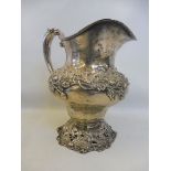 A large Sterling silver jug, with entwined floral design, raised on a pierced floral base, stamped