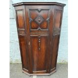 An oak single door wardrobe/cupboard, with geometric mouldings.