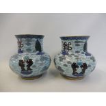 A pair of bulbous cloisonne vases with stylised decoration on pale blue ground, 6" high.
