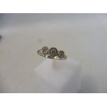 A cased 18ct white gold three stone diamond ring, size N/O, approx. 4.9g.