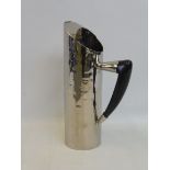 An Arts and Crafts style white metal water jug with ebonised handle, approx. 12" high.