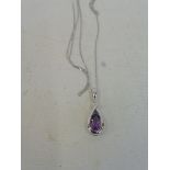 A cased amethyst and diamond pendant on a silver chain.