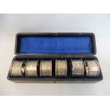 A cased set of six silver plated napkin rings 1-6.