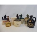 A Wade Bells whisky jug plus a small Bells bell-shaped decanter; also five whisky stoneware jugs/