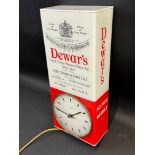 A wall hanging Smiths electric clock within a plastic case advertising Dewar's Finest Scotch Whisky,