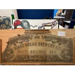 A Birkenhead Brewery Co's Nut Brown Ale glass advertising panel, broken, with wooden panel for