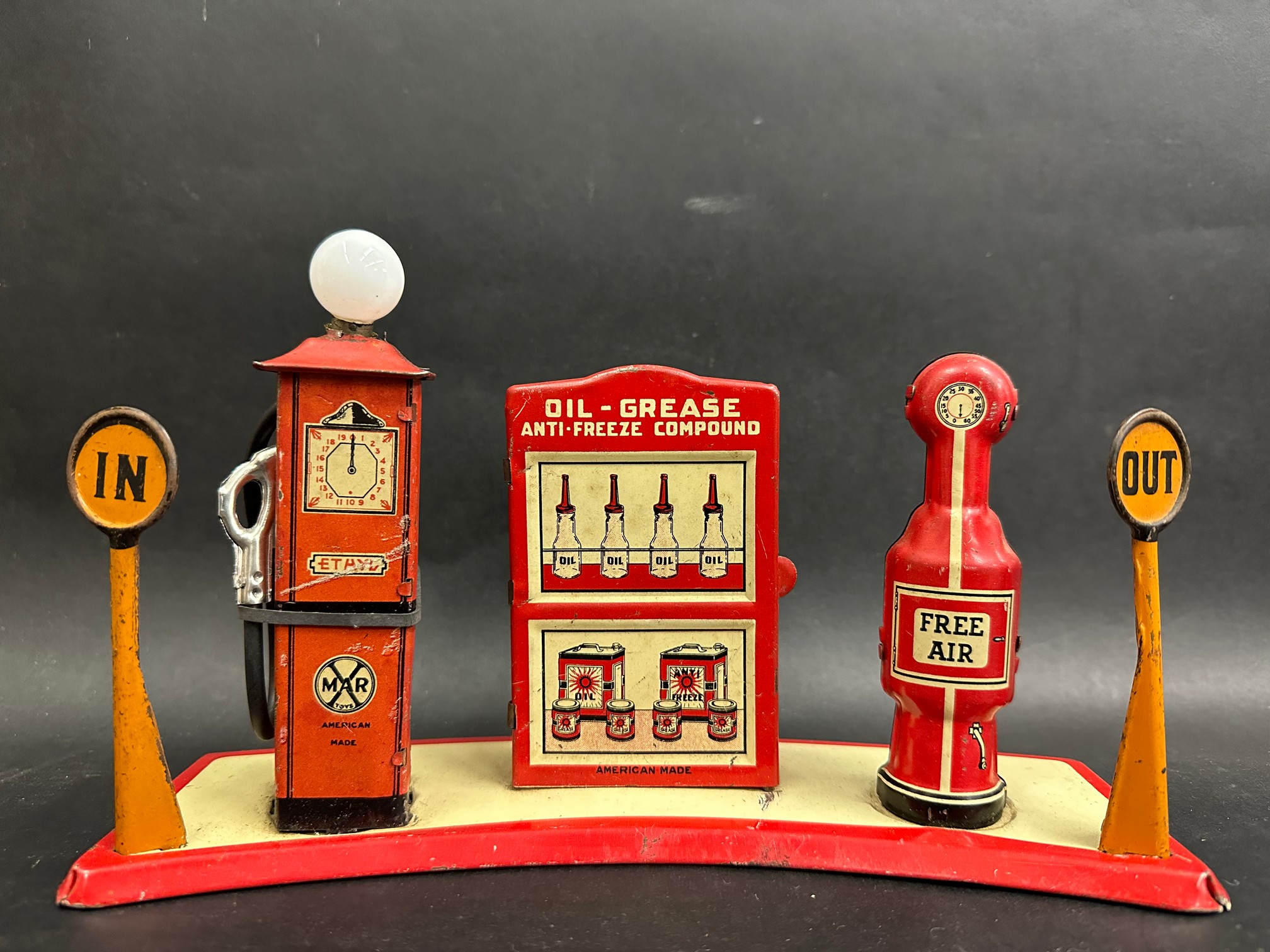 A Marx tinplate petrol filling station, with two petrol pumps flanking a central oil cabinet.