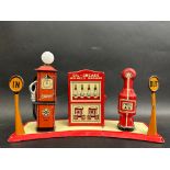 A Marx tinplate petrol filling station, with two petrol pumps flanking a central oil cabinet.