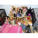 Two boxes of assorted Barbie, Bratz, Action Man figures/dolls with assorted clothes and accessories.