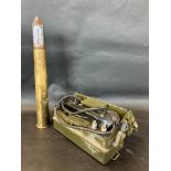 A military field telephone and a shell casing with chrome plated tip.