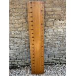 An oversized wooden rule, approx 6.5' tall, for measuring children as they grow.