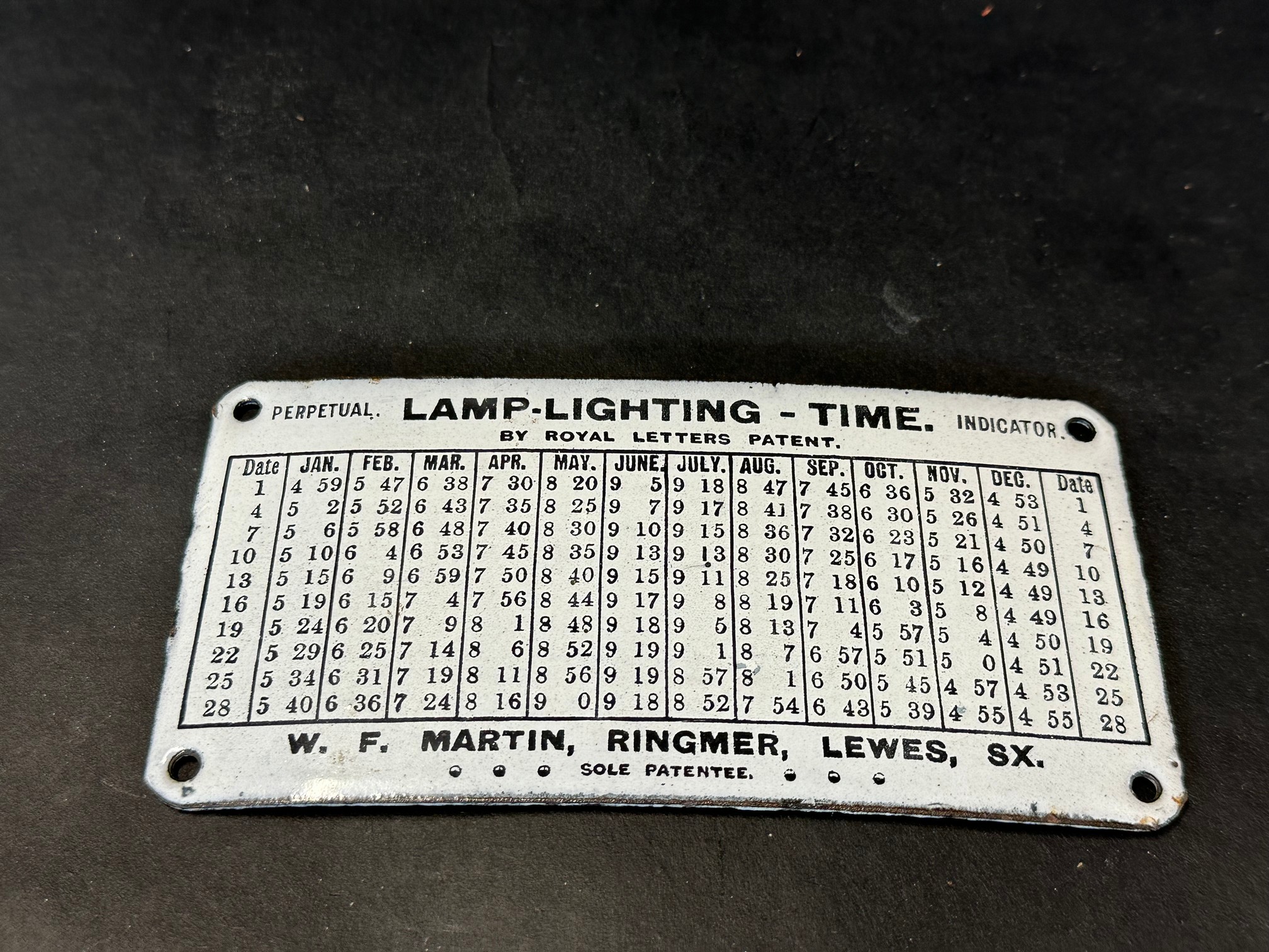 A small Lamp-Lighting-Time indicator sign, in very near mint condition, 6 1/4 x 3/14".