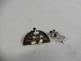 A silver and enamel Mickey Mouse badge, and one other.