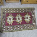 Tribal rugs; a Turkish Rug, hand-knotted with ochre geometric designs on a plum ground,