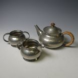 A Tudric pewter three-piece tea set, together with a pewter four-piece coffee service and a