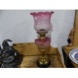 A Victorian brass and etched cranberry glass Oil Lamp, having a cranberry glass font and shade