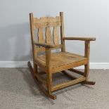 A 20thC carved pine Rocking Chair, W 69cm x H 92.5cm x D 92cm.