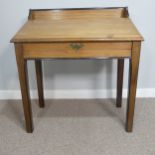 An Edwardian pine Clerk's Desk, with gallery back and lift up writing slope, raised on square