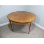 A mid 20thC teak extending Dining Table, of circular form, raised on tapering legs, some scuffs