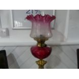 A Victorian Hinks patent brass column Oil Lamp, having a cut cranberry glass font and clear and