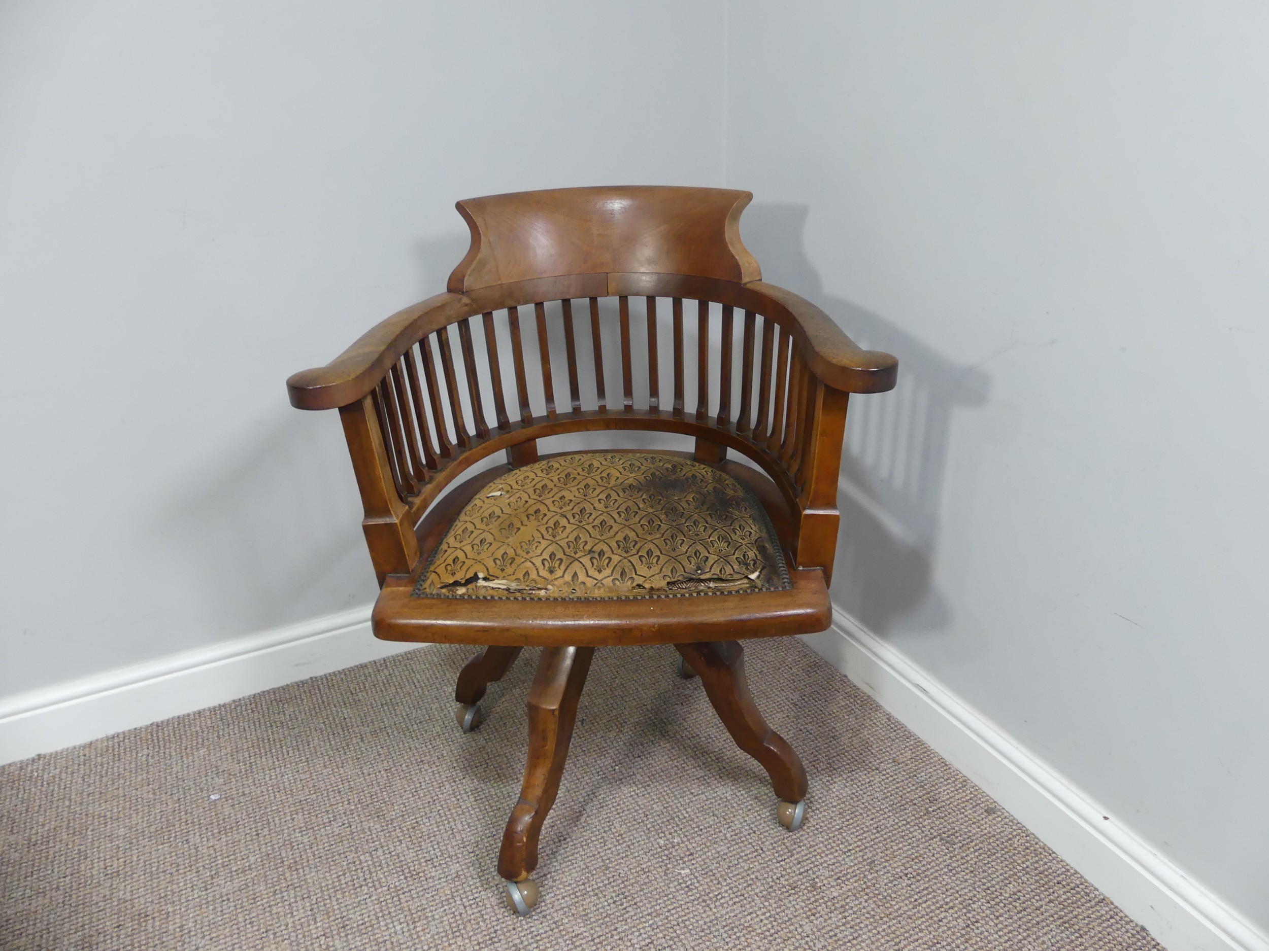 An early 20thC swivel Desk Chair, with spindle back and scroll arms, above an upholstered pad