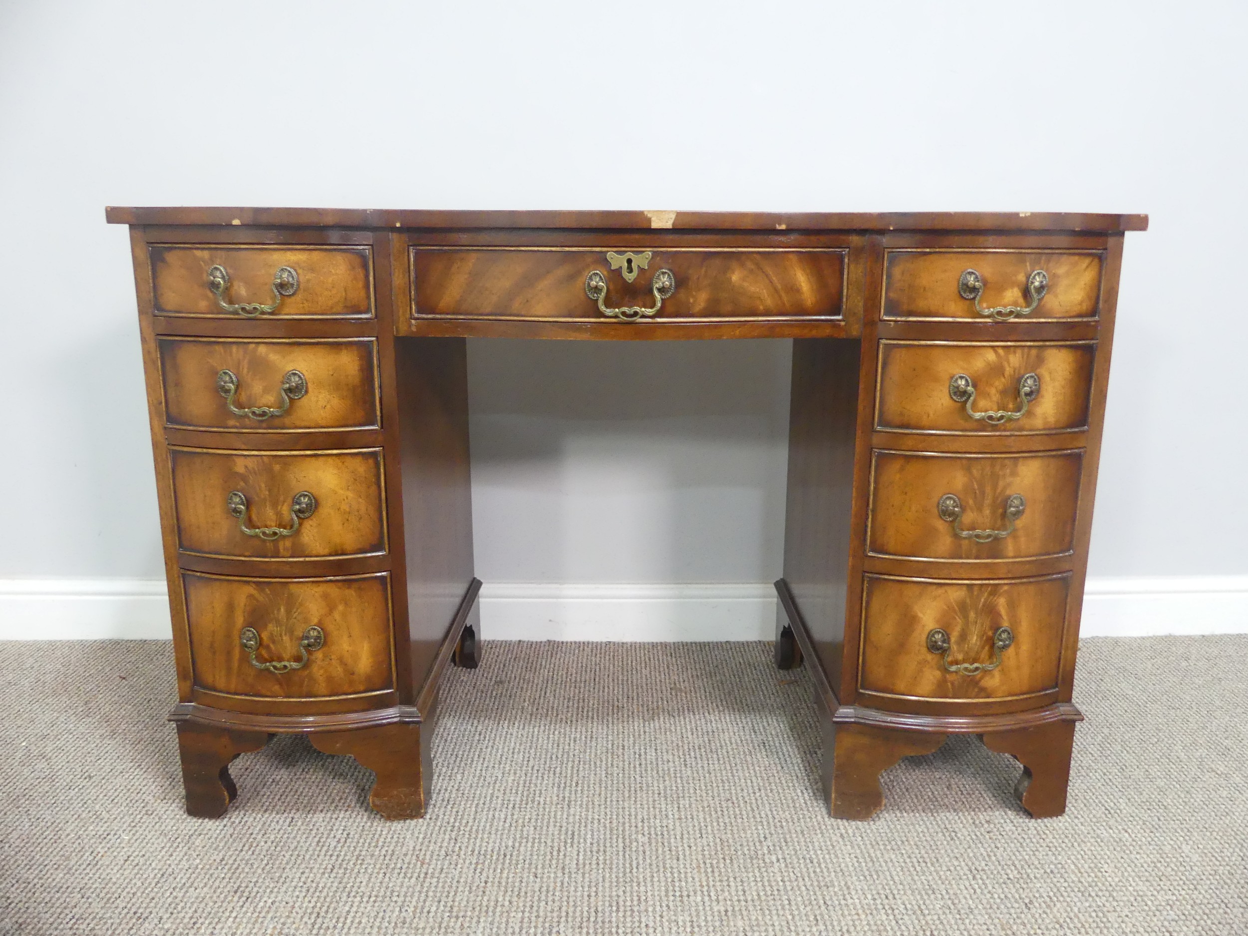 An early 20thC walnut Serpentine-fronted Pedestal Desk, the top with green tooled leatherette inset,