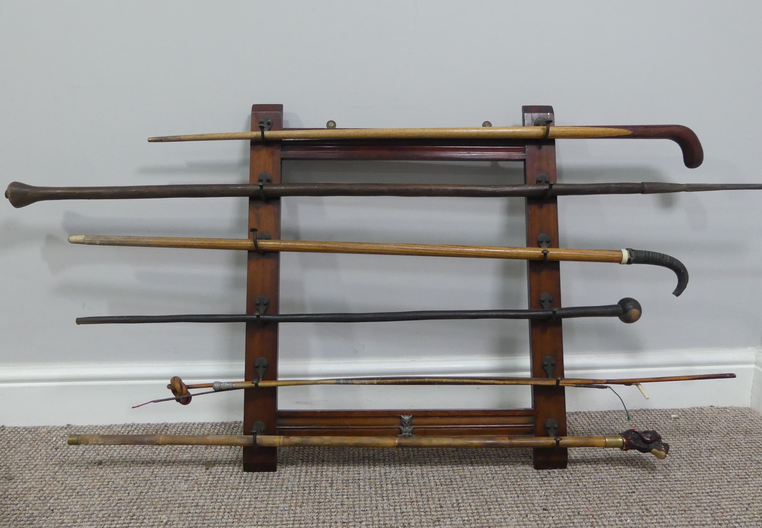 An Edwardian mahogany wall-mounted Stick Stand, with six pairs of hooks, W:51cm x H:61cm, together