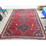 Tribal rugs; a Kashquai Rug, hand-knotted with stylised tree of life and floral designs on a red