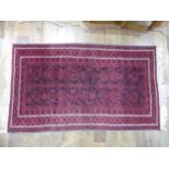 Tribal rugs; an Afghan Rug, hand-knotted with geometric designs on a red ground, 100% wool, fringe