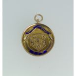 A 9ct gold prize Fob Medallion, the front enamelled 'Sykes Charity Cup', the reverse with