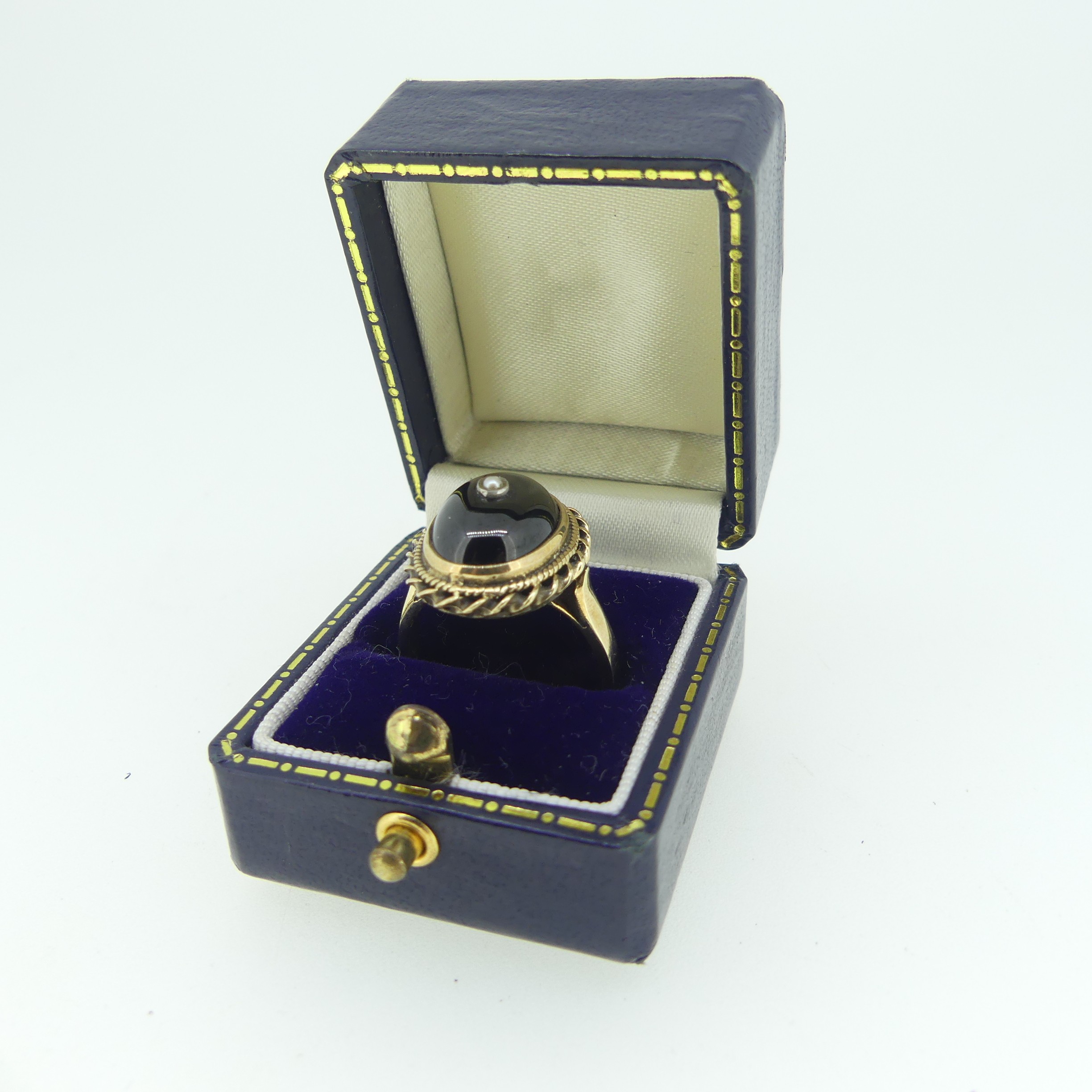 A cabochon garnet Ring, the stone approx. 13.5mm collet set in 9ct gold mount with rope border and