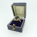 A cabochon garnet Ring, the stone approx. 13.5mm collet set in 9ct gold mount with rope border and