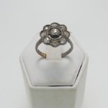 A diamond flowerhead cluster Ring, the central old cut stone approx. 0.13ct, collet set with a